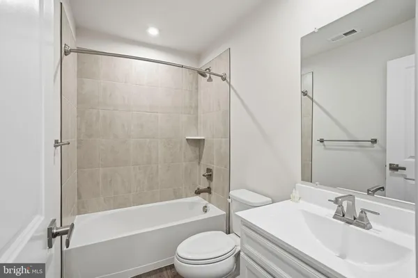 a bathroom with a bathtub shower sink vanity and toilet