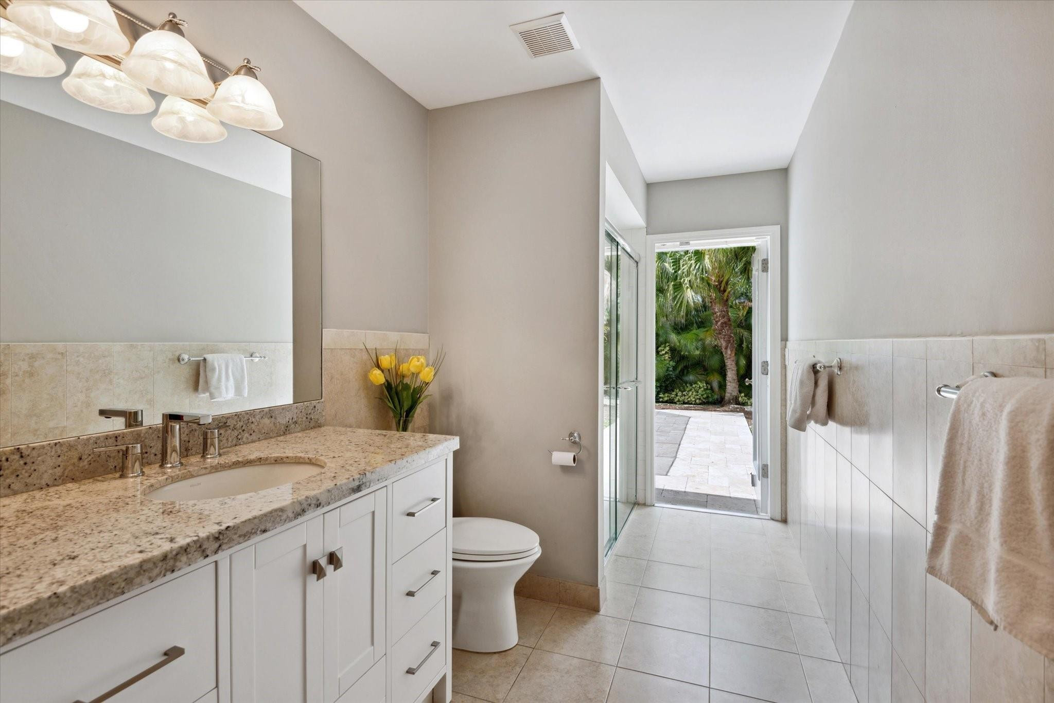 1055 Parkside Circle North Boca Raton, FL 33486 - Photo 17 of 24 a spacious bathroom with a granite countertop sink a toilet a mirror and bathtub