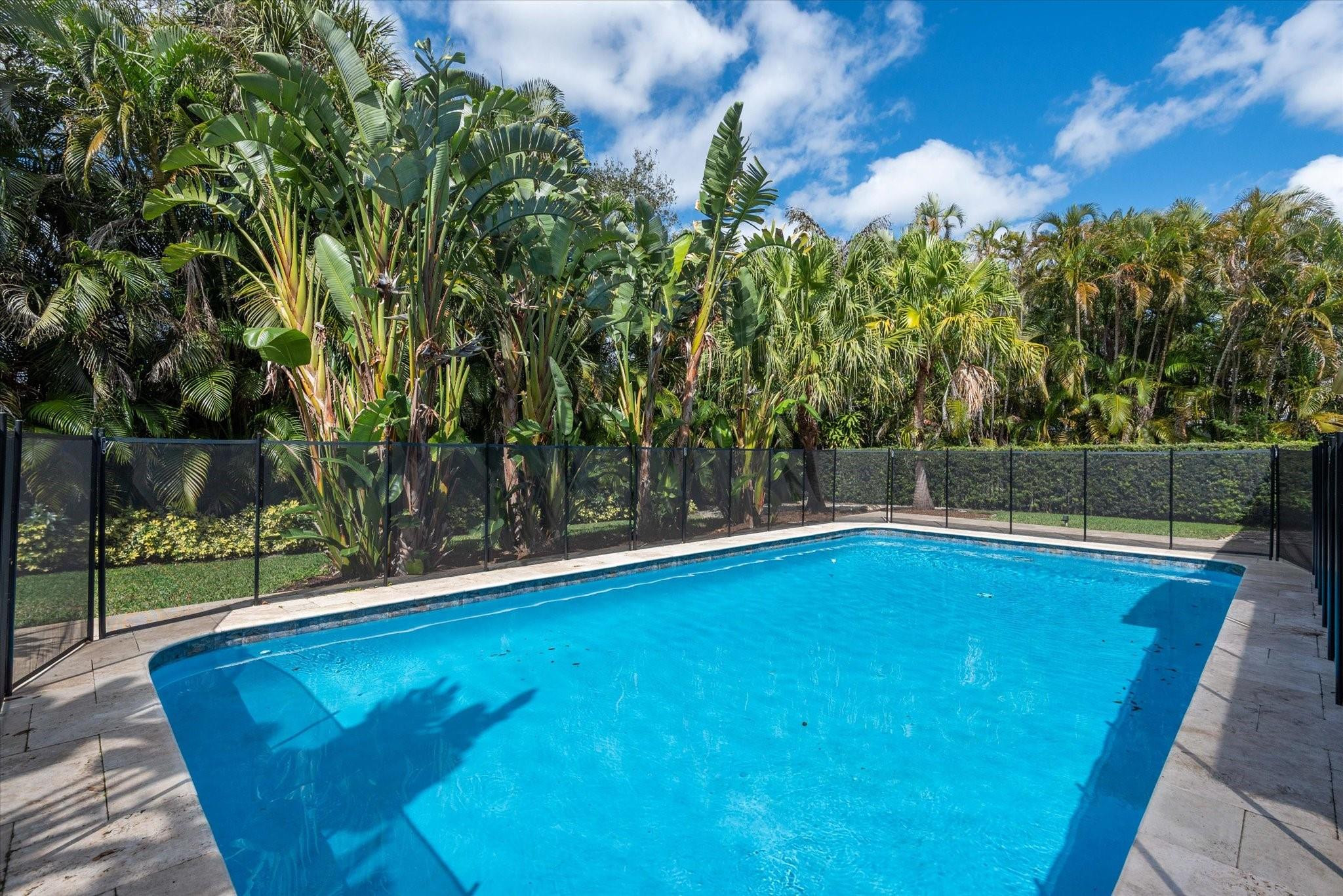 1055 Parkside Circle North Boca Raton, FL 33486 - Photo 22 of 24 a view of a swimming pool and trees in the background