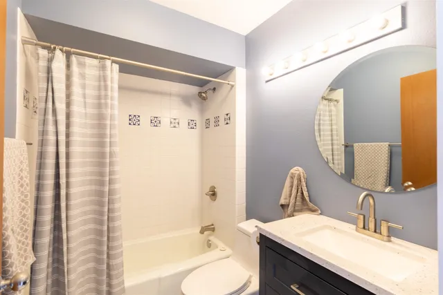 a bathroom with a granite countertop sink toilet and shower
