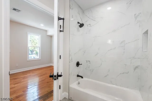 a bathroom with a bathtub with shower