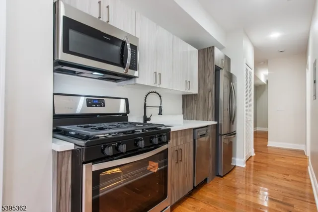 a kitchen with stainless steel appliances a stove a microwave a sink and cabinets