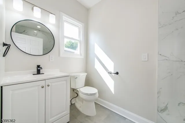 a bathroom with a toilet a sink and a mirror