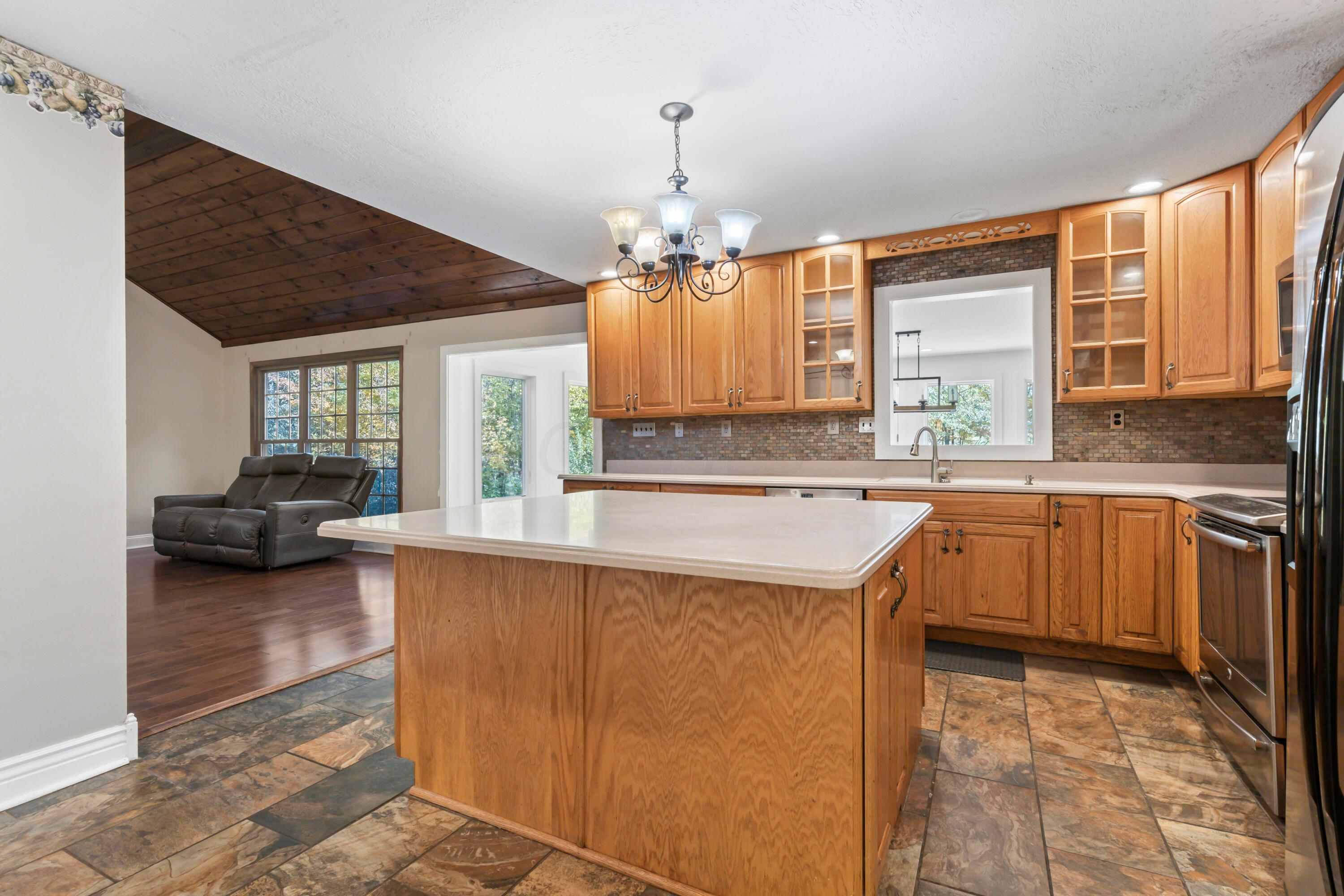 9495 Kilbourne Road Sunbury, OH 43074 - Photo 19 of 84 • Completely updated ~2003
• New slate flooring ~2014
• Tan painted walls
• Corian countertops
• 5’ x 5’ center island with
breakfast bar ledge
• 42” oak, raised panel cabinets
• New Bosch® dishwasher
~10/2014
• Extra deep, double bowl sink
with sprayer
• New Frigidaire® microwave
~2013
• New General Electric® electric
range ~2015
• New Whirlpool® refrigerator
~2012/2013
• Slate tile backsplash
• Insinkerator® disposal
• Can lighting
• Hanging light
• Pantry with glass front door
• Second pantry