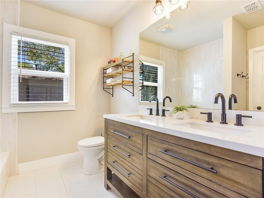 3304 Robinson Avenue, Unit 1 Austin, TX 78722 - Photo 9 of 13 Updated primary bathroom with double vanity, modern fixtures, and clean contemporary finishes—a rare find in a Central Austin bungalow.