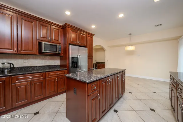 a kitchen with stainless steel appliances granite countertop wooden cabinets a granite counter tops and a sink