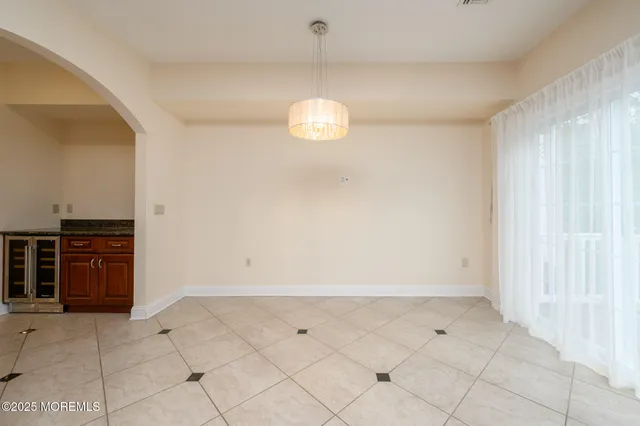 a view of an empty room with kitchen and stove