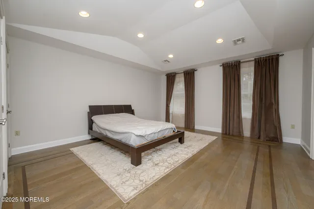 a room with a bed and a wooden floor