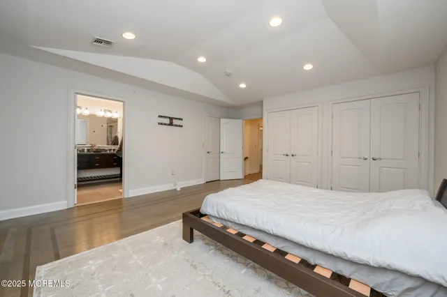 a spacious bedroom with a bed and a view of kitchen