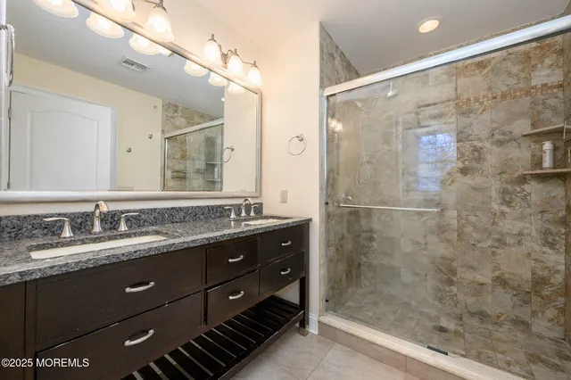 a bathroom with a granite countertop sink a shower and a mirror