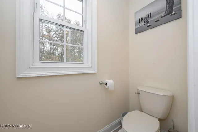 a white toilet sitting next to a window