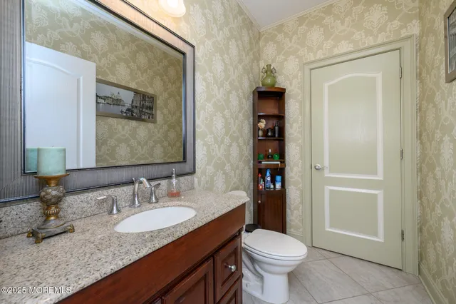a bathroom with a granite countertop toilet sink and mirror