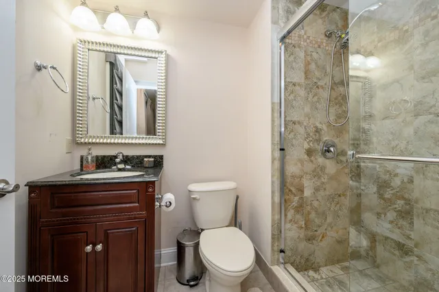 a bathroom with a toilet a sink a mirror and shower