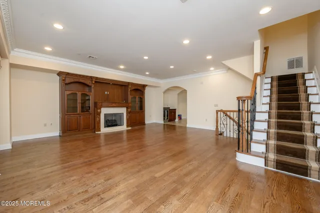 a view of a living room with wooden floor and a fireplace