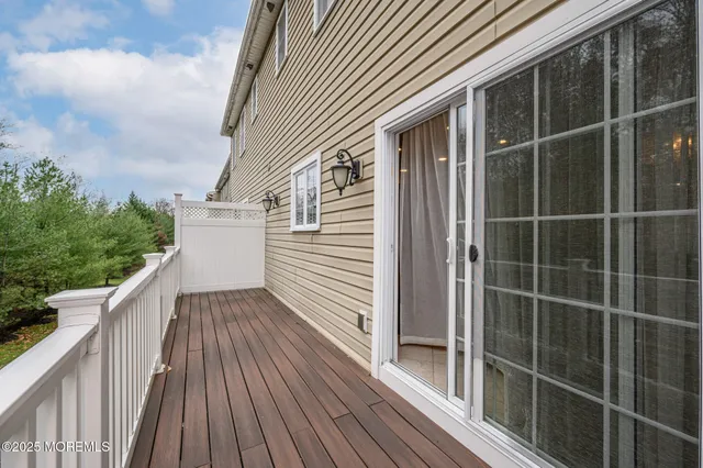 a view of a balcony with wooden floor and fence