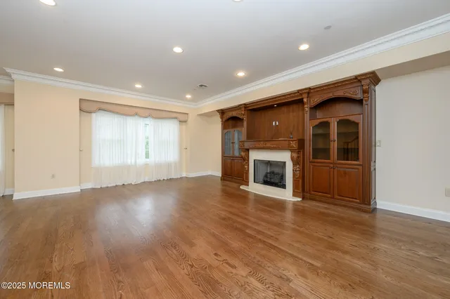 a view of empty room with wooden floor and fireplace
