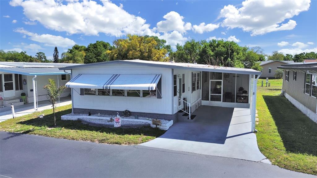 9900 Ulmerton Road, Unit 238 Largo, FL 33771 - Photo 1 of 22 a view of a house with a big yard potted plants and a fountain