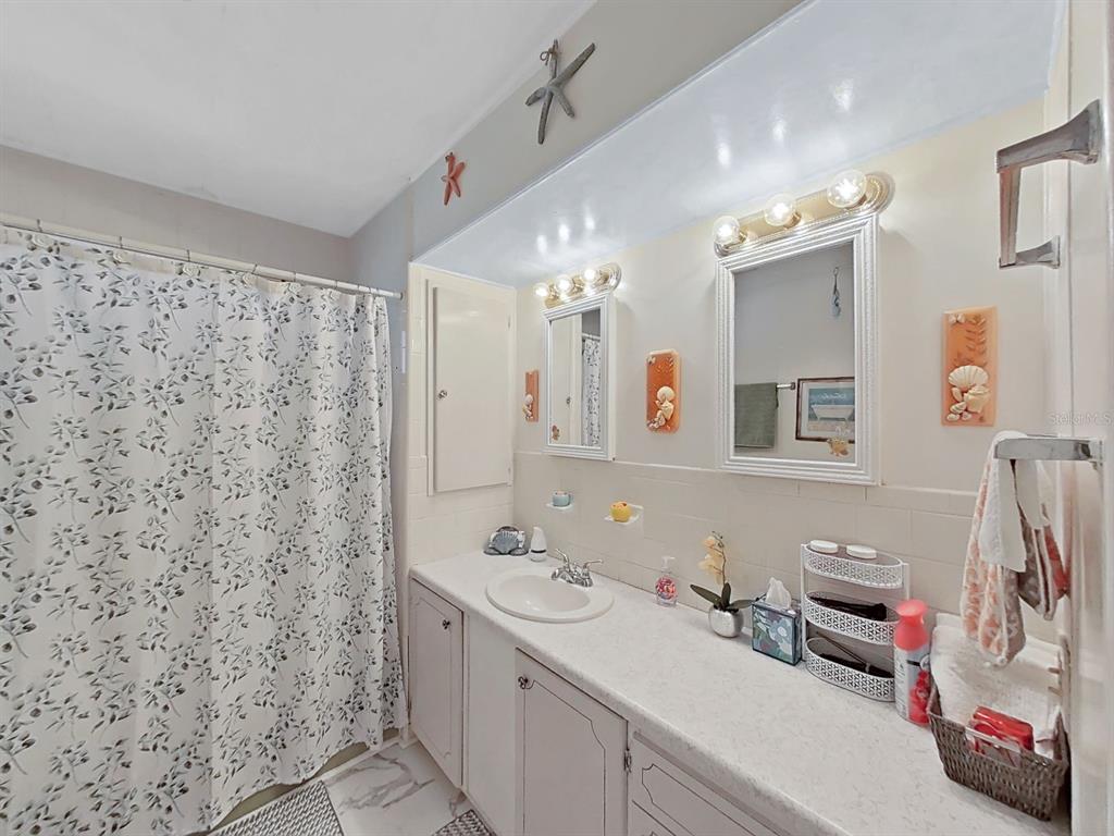 9900 Ulmerton Road, Unit 238 Largo, FL 33771 - Photo 16 of 22 a bathroom with a sink vanity and a mirror