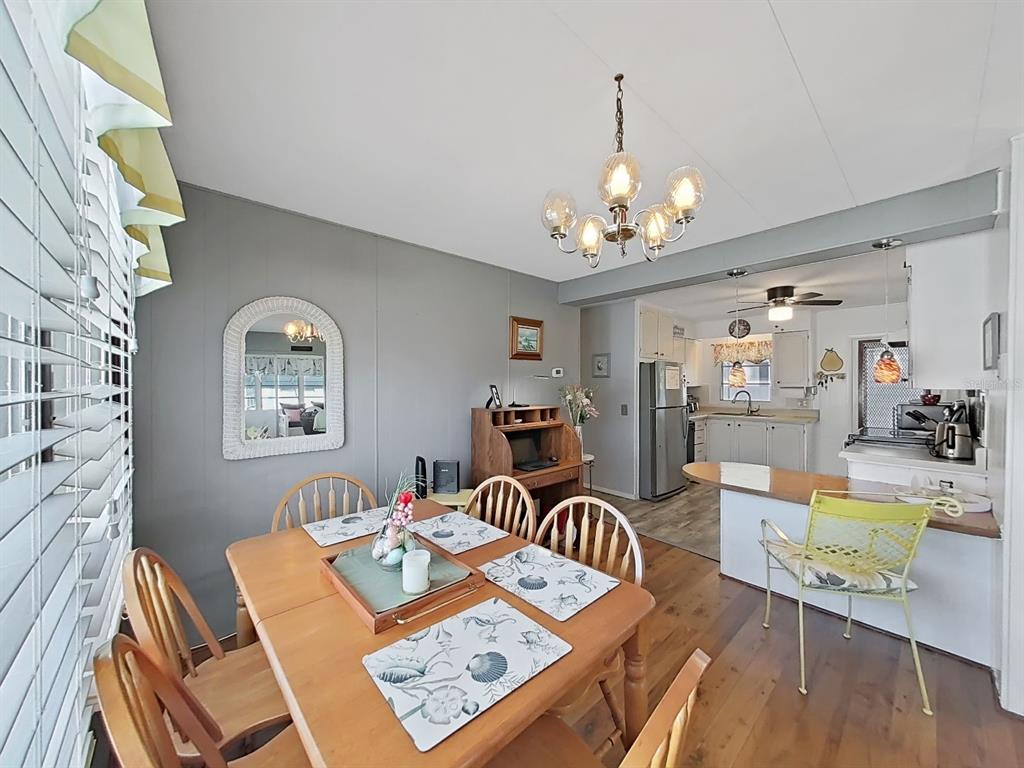 9900 Ulmerton Road, Unit 238 Largo, FL 33771 - Photo 7 of 22 a view of a dining room with furniture a chandelier and wooden floor