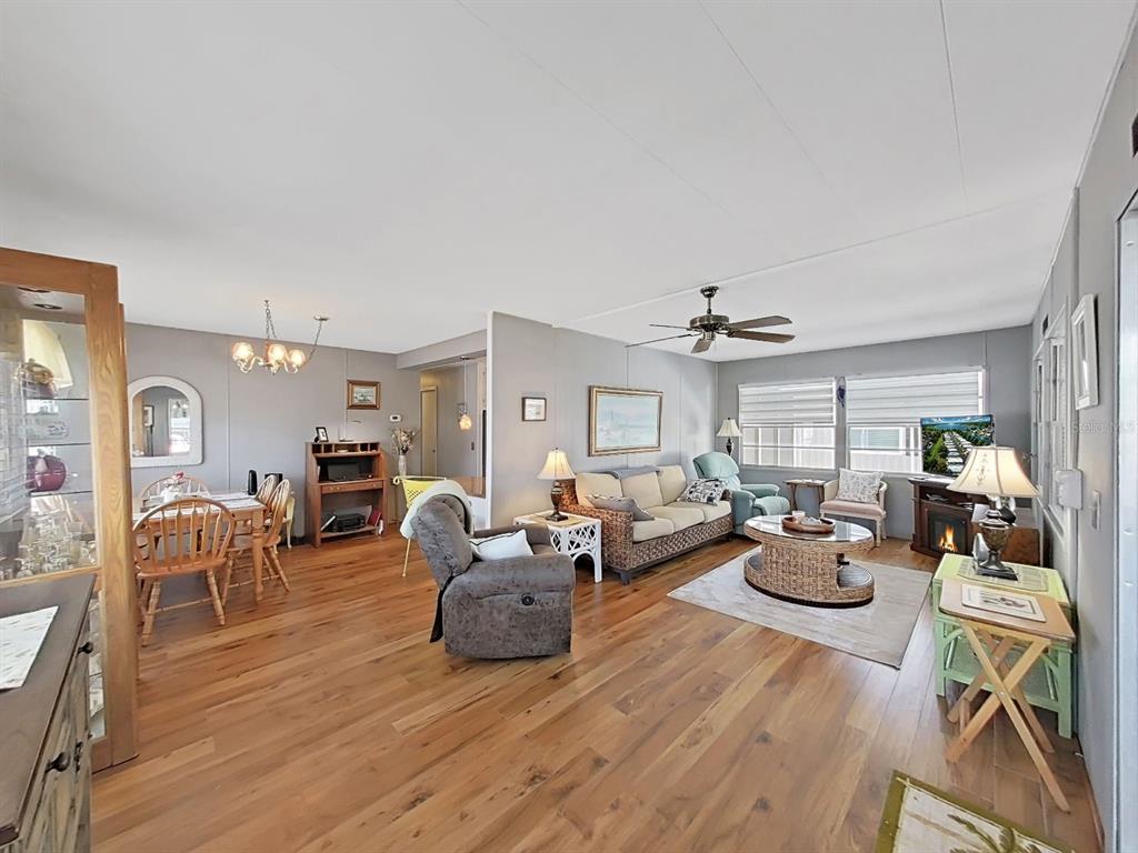 9900 Ulmerton Road, Unit 238 Largo, FL 33771 - Photo 8 of 22 a living room with lots of furniture a chandelier and a table