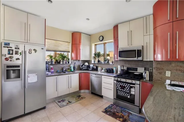 a kitchen with stainless steel appliances granite countertop a refrigerator sink and microwave