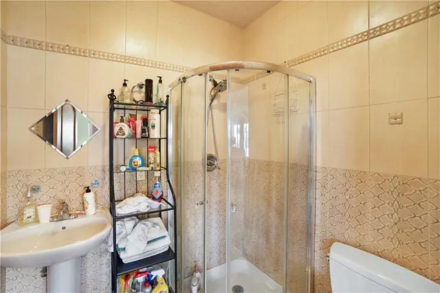 a bathroom with a shower toilet and sink