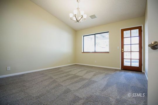 608 Amanda Street Ridgecrest, CA 93555 - Photo 17 of 30 an empty room with windows and chandelier