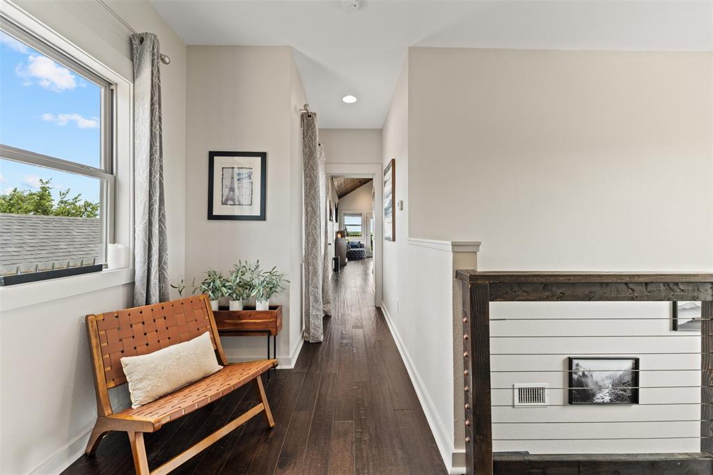 124 Bluffview Circle China Spring, TX 76633 - Photo 23 of 40 Upper-level hallway to primary bedroom featuring dark wood-finish flooring, a contemporary window with natural light, recessed ceiling lighting, a white painted railing with cable infill, and wainscoting