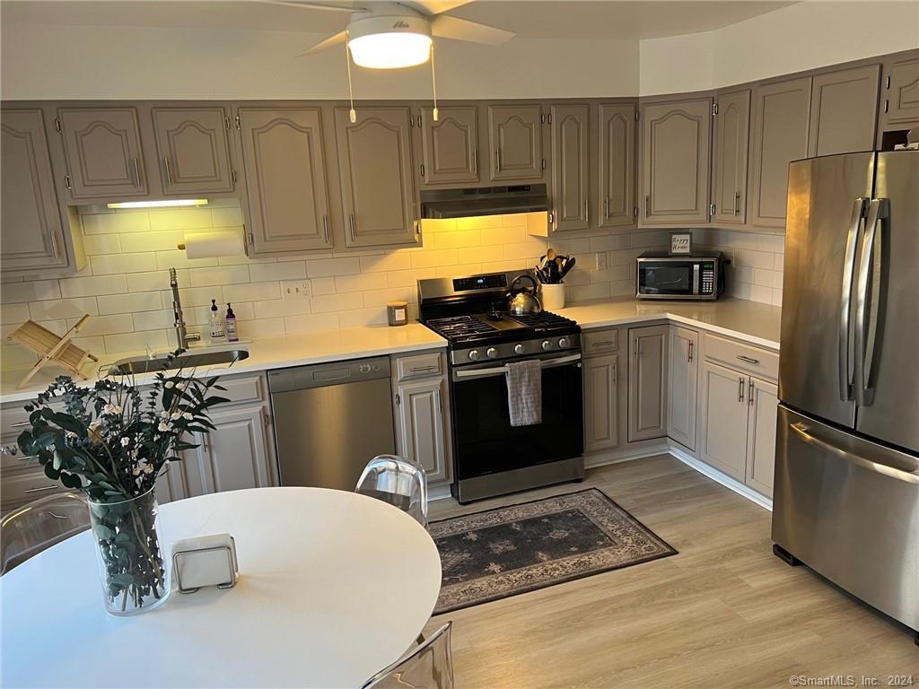 a kitchen with stainless steel appliances granite countertop a sink stove and refrigerator