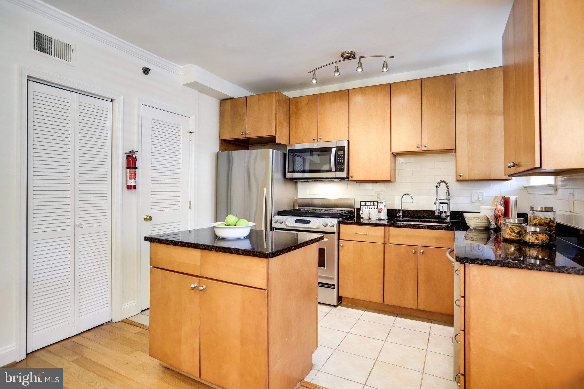 1438 Columbia Road Northwest, Unit 101 Washington, DC 20009 - Photo 14 of 39 a kitchen with stainless steel appliances granite countertop a stove a sink and a refrigerator