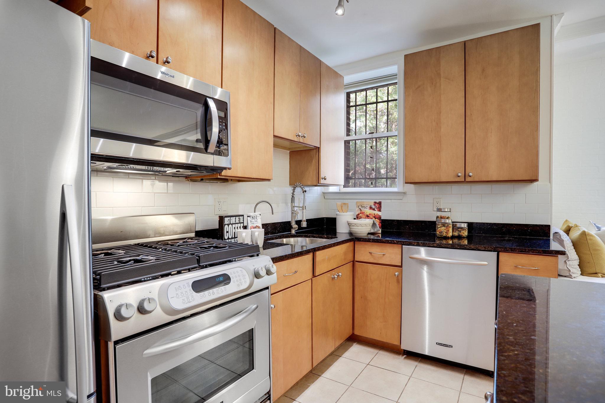 1438 Columbia Road Northwest, Unit 101 Washington, DC 20009 - Photo 19 of 39 a kitchen with white cabinets and appliances