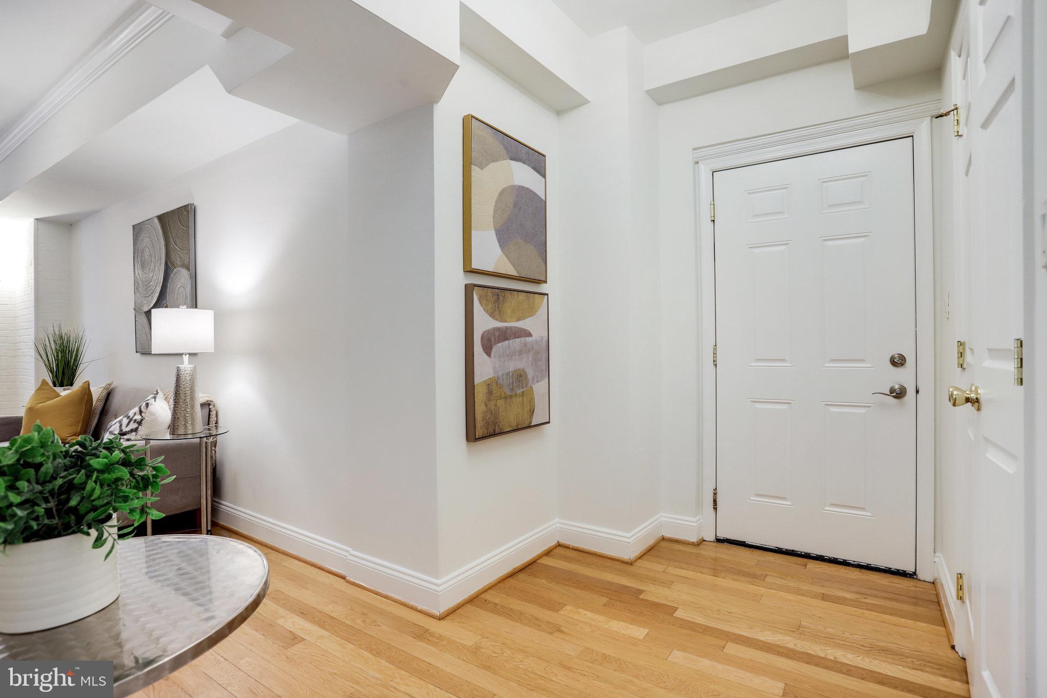1438 Columbia Road Northwest, Unit 101 Washington, DC 20009 - Photo 7 of 39 a view of a livingroom with wooden floor and a potted plant