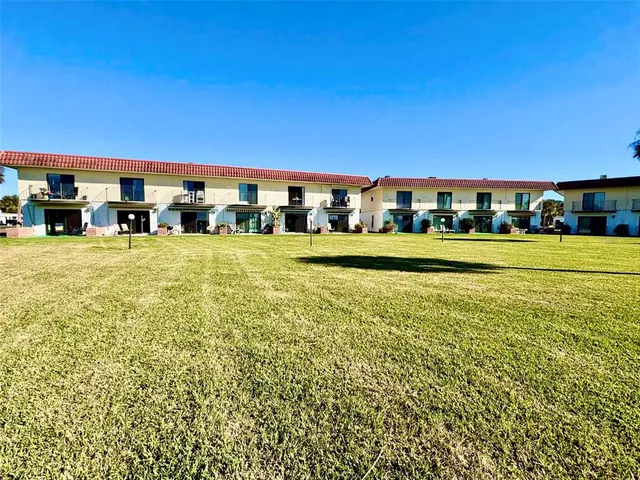 a view of a big room with a big yard and large trees