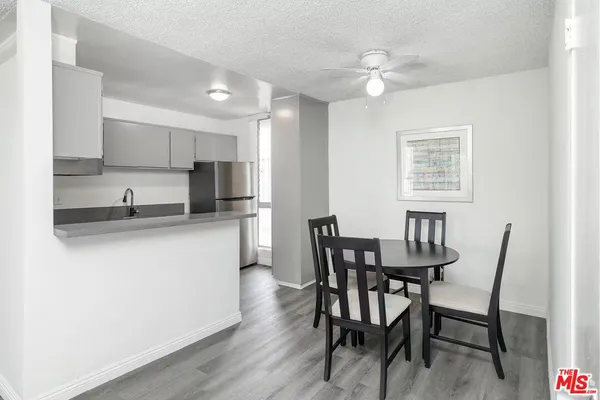 a kitchen with kitchen island a dining table and chairs