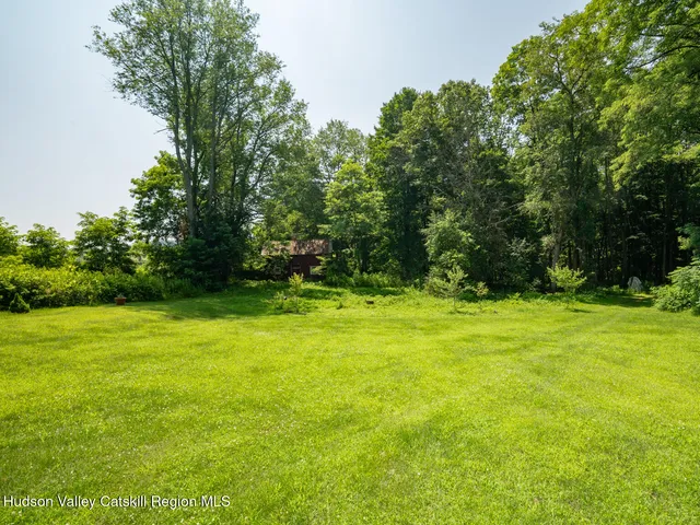 a view of a field of grass and trees