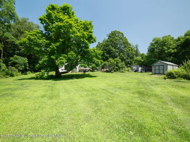 a backyard of a house with a yard and outdoor seating