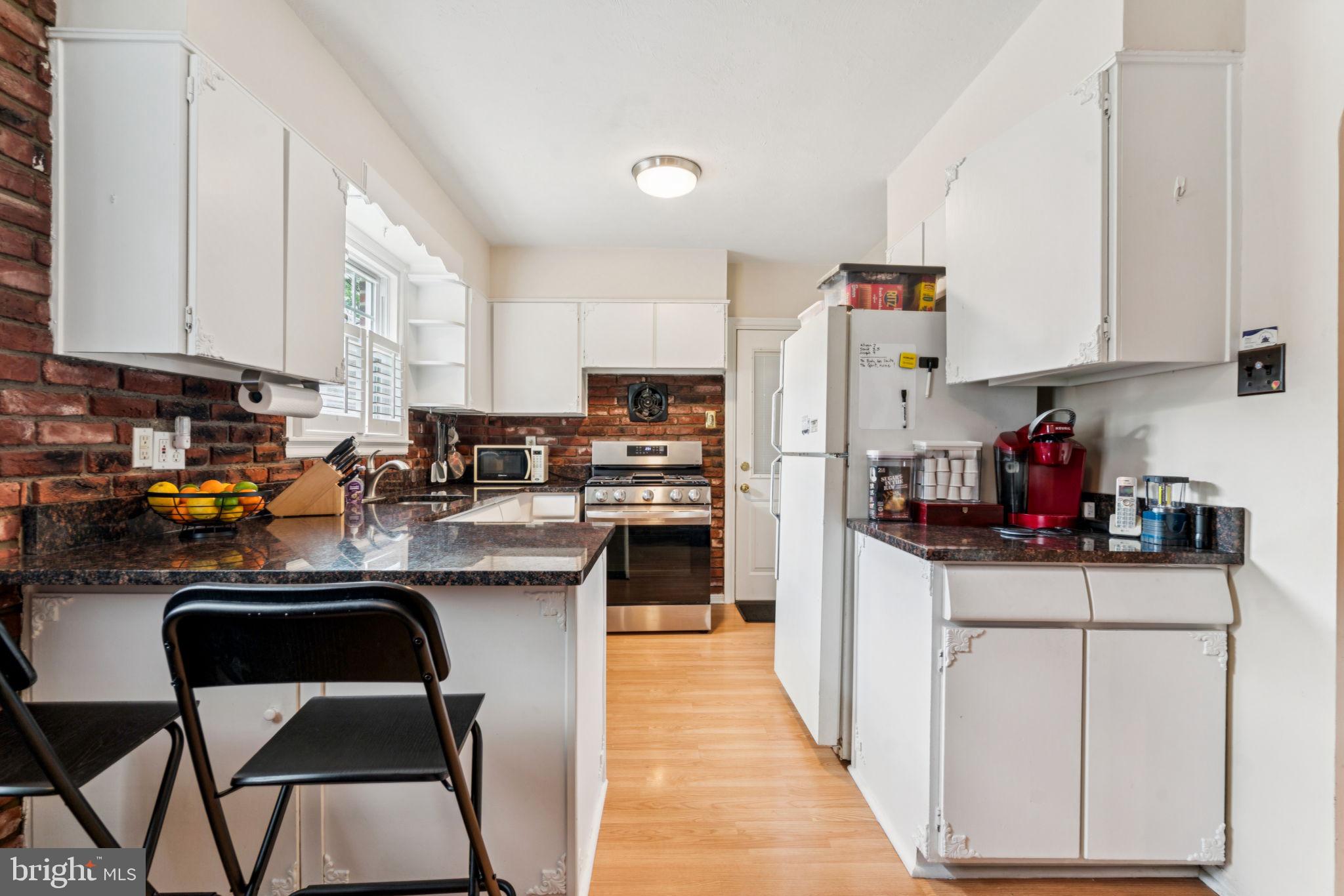6768 Stenton Avenue Philadelphia, PA 19119 - Photo 18 of 76 a kitchen with stainless steel appliances kitchen island granite countertop a refrigerator sink and cabinets