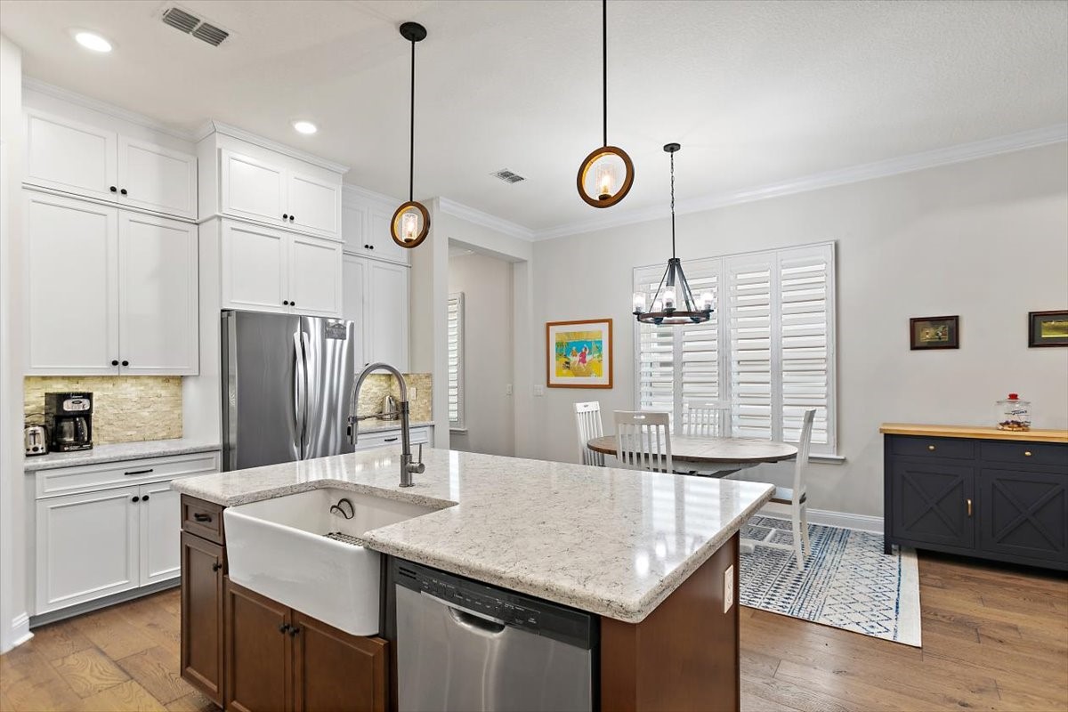 96014 Enclave Manor Fernandina Beach, FL 32034 - Photo 8 of 32 a kitchen with center island a sink appliances and cabinets