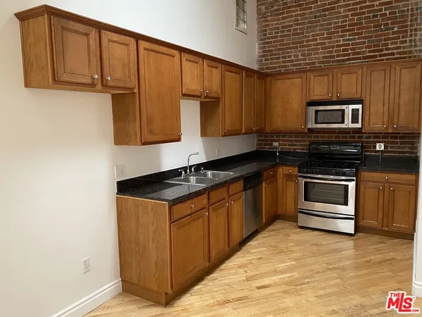 a kitchen with stainless steel appliances granite countertop a stove and a microwave