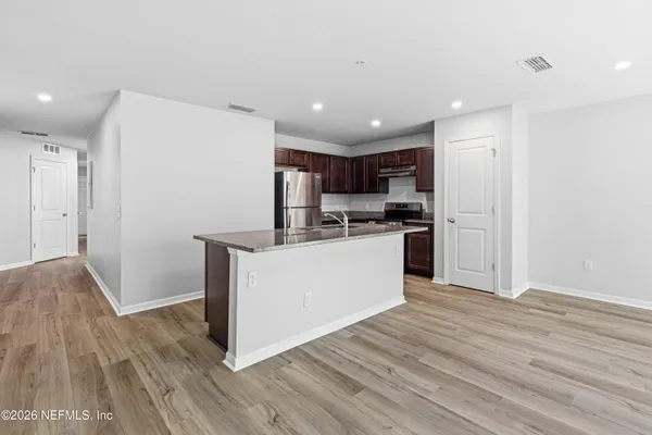 a kitchen with stainless steel appliances granite countertop a refrigerator a stove a sink and a microwave