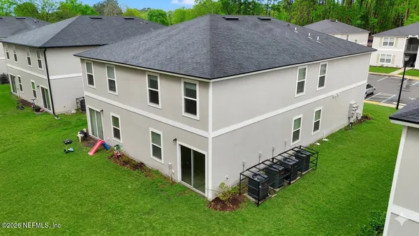 a aerial view of a house next to a big yard and large trees