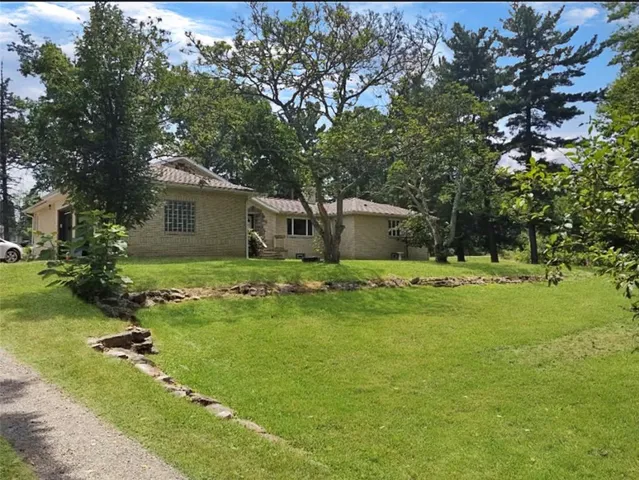 a front view of house with yard and trees