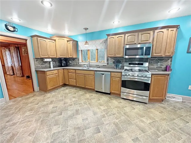 a large kitchen with a sink and stainless steel appliances