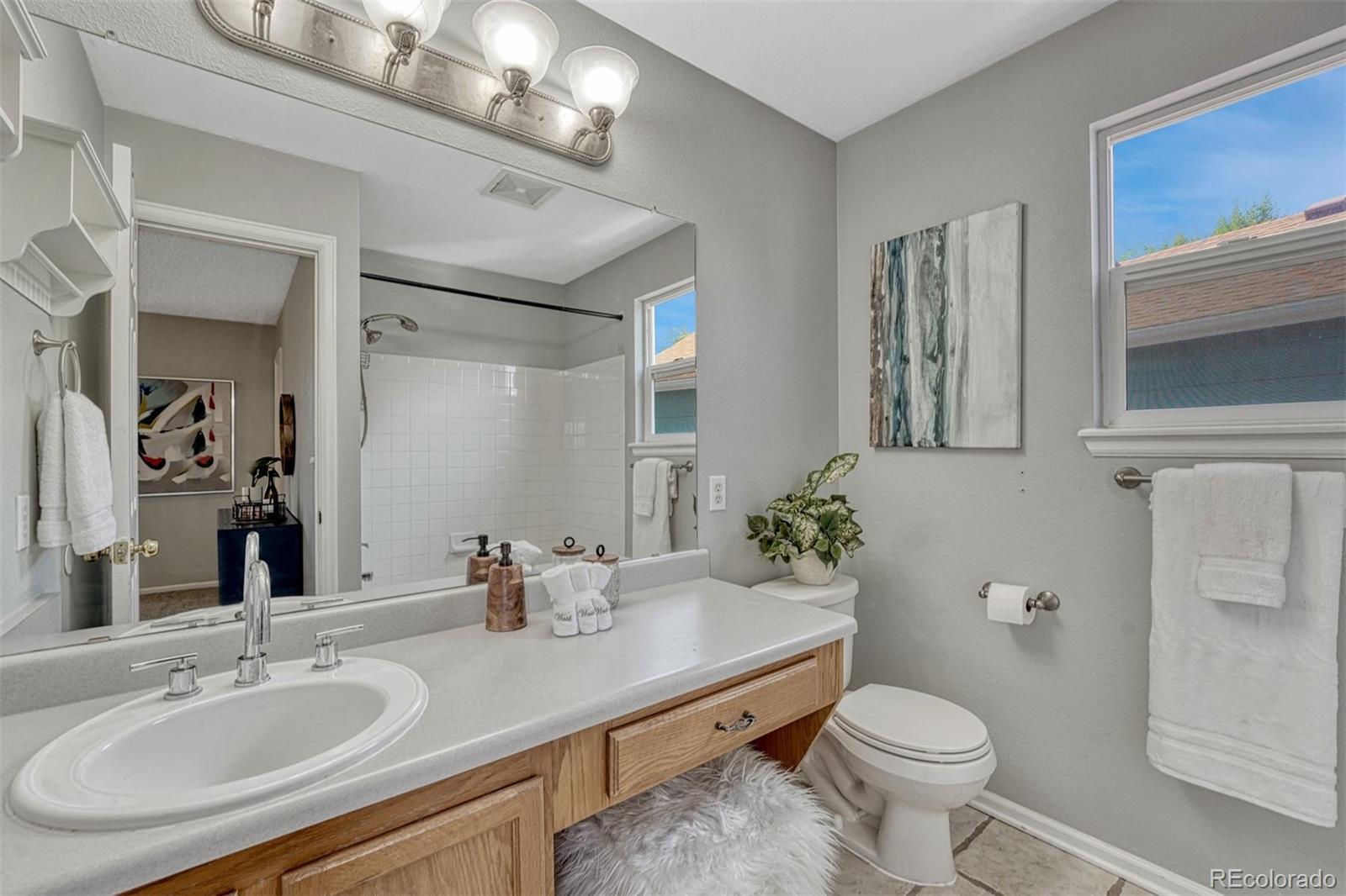 4927 Tarcoola Lane Highlands Ranch, CO 80130 - Photo 14 of 30 a bathroom with a granite countertop toilet sink and mirror