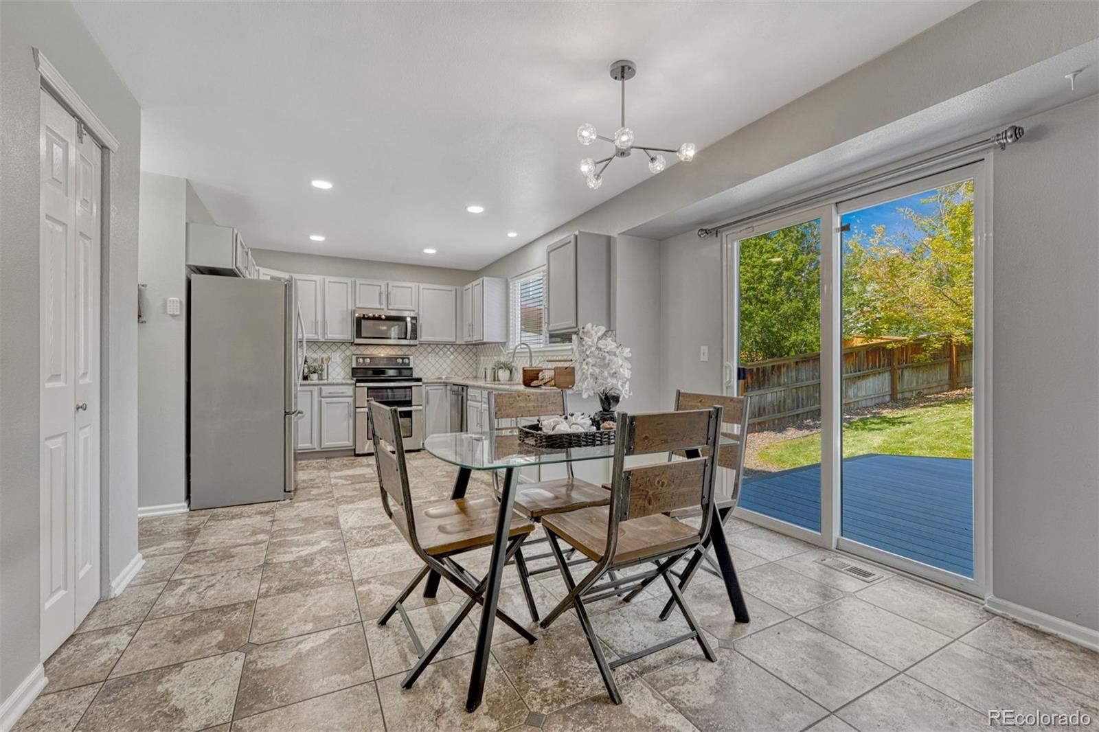 4927 Tarcoola Lane Highlands Ranch, CO 80130 - Photo 7 of 30 a view of a dining room and livingroom with furniture wooden floor a chandelier