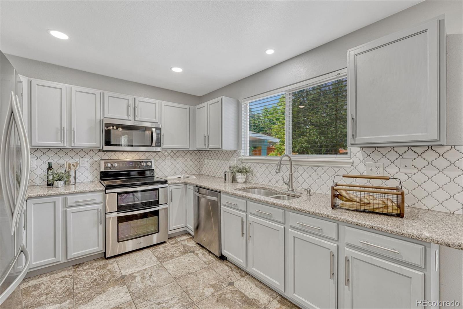 4927 Tarcoola Lane Highlands Ranch, CO 80130 - Photo 9 of 30 a kitchen with appliances a sink and cabinets