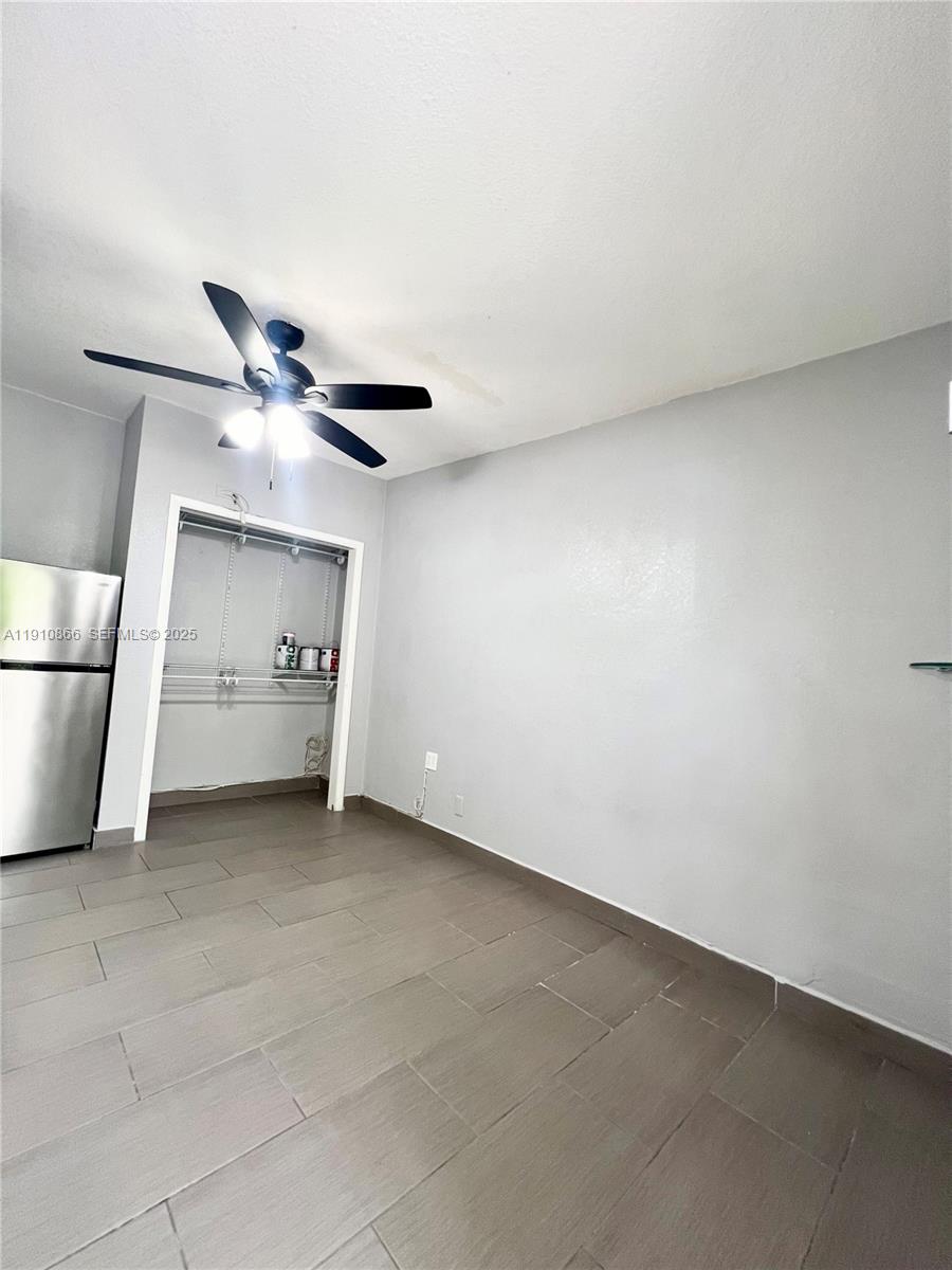 a view of an empty room and a ceiling fan