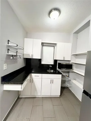 a kitchen with stainless steel appliances a sink a stove and white cabinets