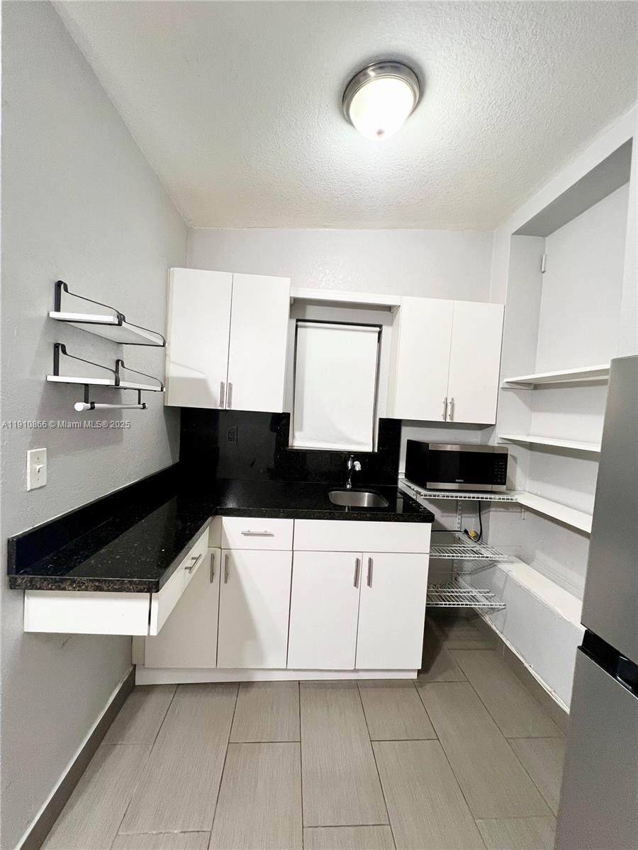 1400 Southwest 29th Avenue, Unit 3 Miami, FL 33145 - Photo 3 of 4 a kitchen with stainless steel appliances a sink a stove and white cabinets
