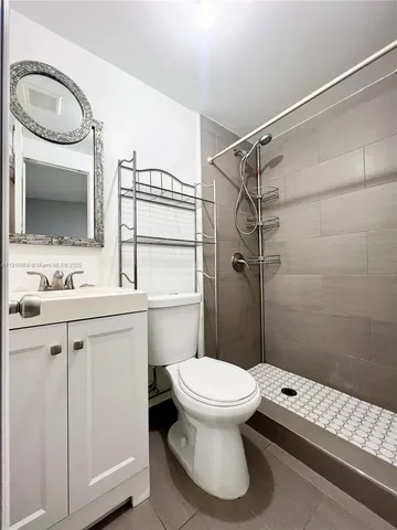 a bathroom with a sink a toilet a mirror and shower